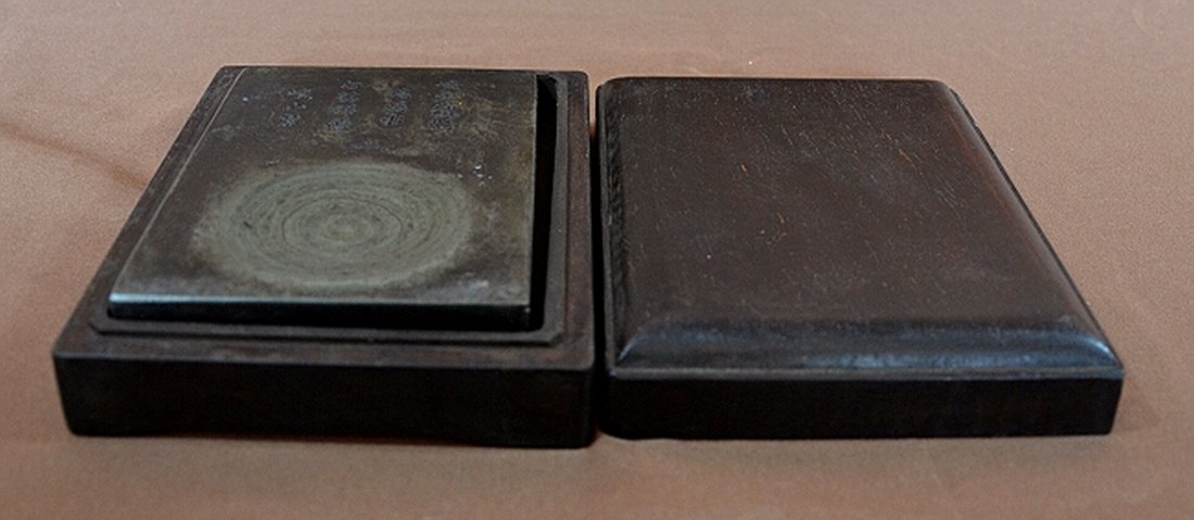 Duan Inkstone With Zitan Wood Box: A boxed Zitan wood Duan ink-stone, with Chinese poem inscribed on the lid. Box measures 7" X 5". Shipping: We are able to pack and ship this item to an address in the United States for $30.00 via USPS