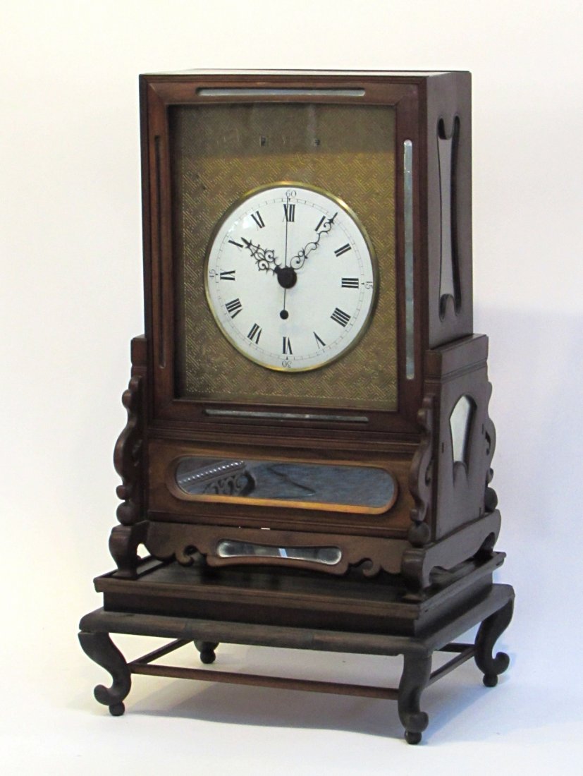 Chinese Table Clock: An exceptional example of a late 18th or early 19th century Chinese table clock featuring calendar apertures through the engraved dial mask, round porcelain dial, and engraved back plate; including a 
