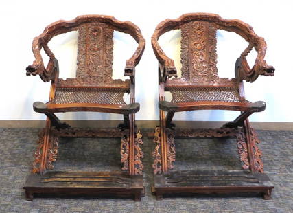 Pair Large Huang Hua Li Folding Chairs: Pair large Huang Hua Li folding chairs With wrap around horseshoe armrests, highly carved with a rectangular carved back splat. Metal finishings on the foot rests. 44" x 31" x 33" open Shipping: We ar