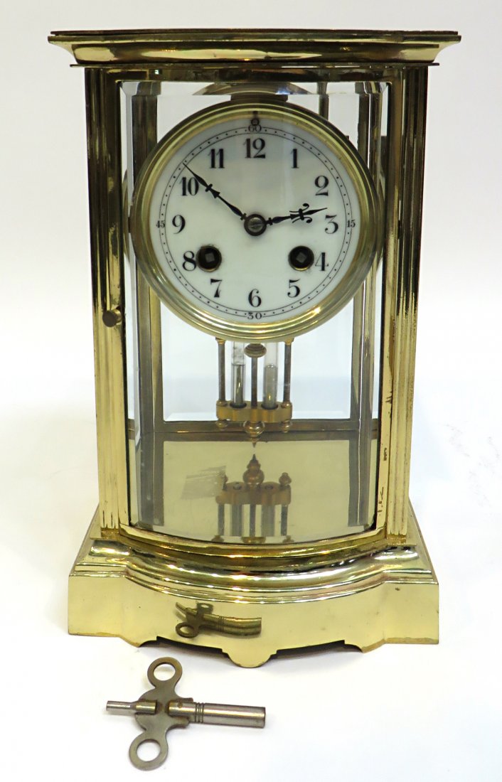 Late 19th C. French Mantel Clock: A polished brass and lacquered bow front brass and bevel glass French made mantel clock with a Mercury pendulum. In excellent condition, and appears to be in good running order. 10" Shipping: We are a