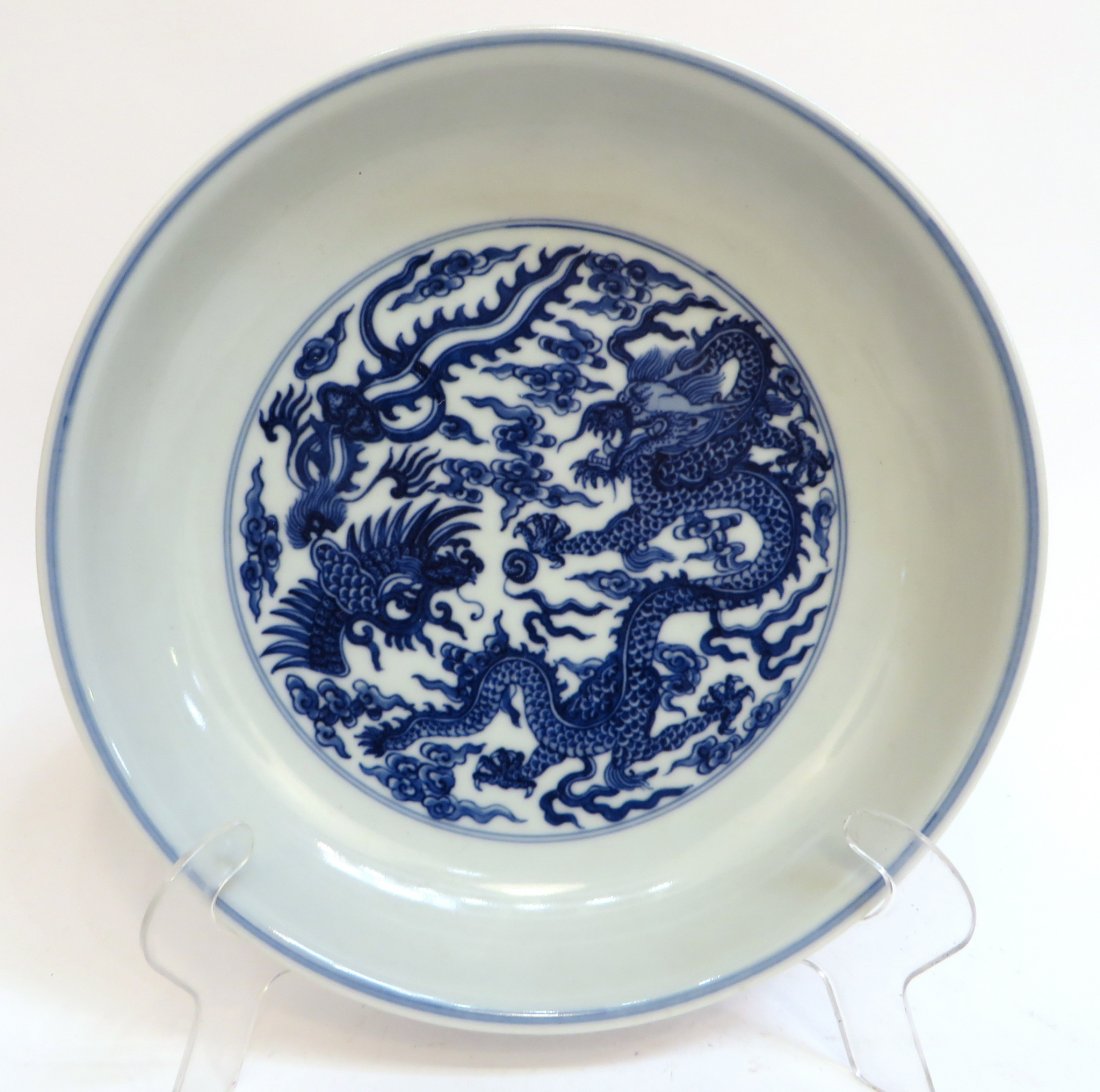 Yongzheng Blue And White Porcelain Shallow Bowl: Yongzheng Blue And White Porcelain Shallow Bowl: A dragon and phoenix with a flaming pearl and clouds in center of interior. Outside, another dragon and phoenix. Yong Zheng mark on bottom.