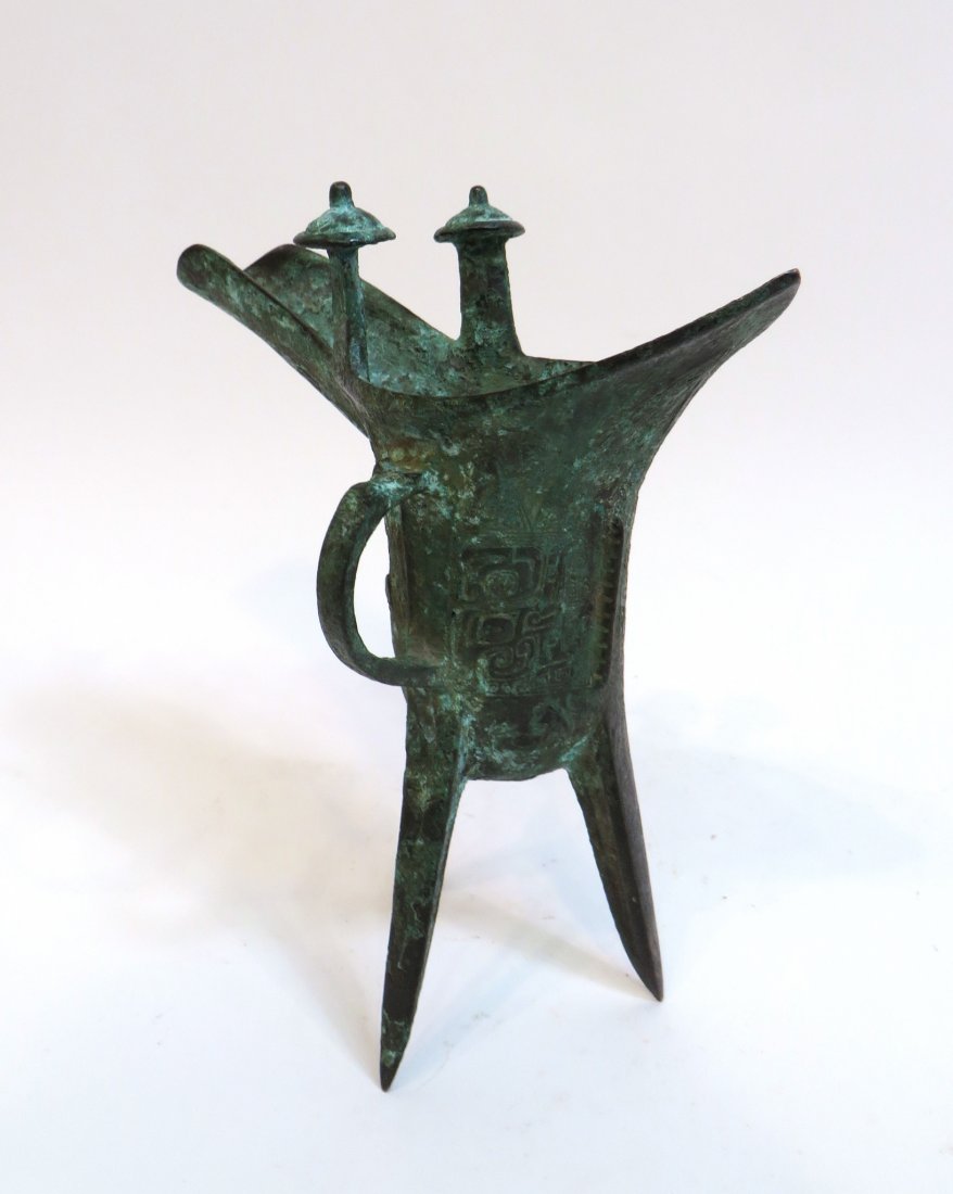 Shang Dynasty Style Bronze Jue Vessel: Shang Dynasty Style Bronze Jue Vessel : There is a crescent-shaped handle on one side as well as two protuberances on the upper rim to lift after being heated. In green patina and in very good condit