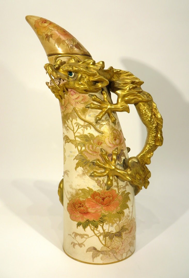 Japanese Style Doulton Burslem Lidded Flask: Japanese Style Doulton Burslem Lidded Flask: In the form of a tusk with entwined heavily gilded dragon handle and flower and leaf motifs against an ivory ground. The lid repaired.