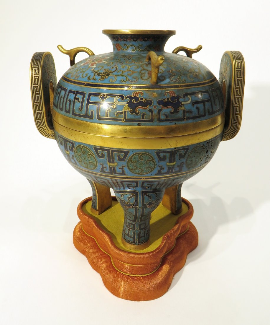 CLOISONNÉ CENSER ON FABRIC STAND: Cloisonné Censer On Fabric Stand: A tripod censer with floral meander and dragon patterns sitting on fitted fabric covered stand. Four character mark on the bottom.