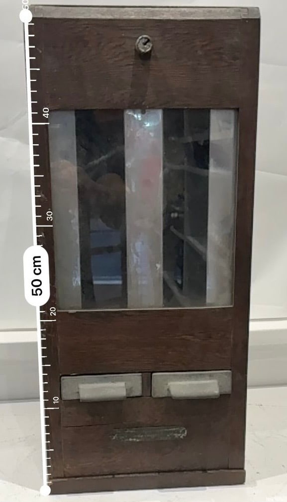 WOODEN CIGARETTE MACHINE: A wooden cigarette machine is a vintage cigarette dispenser/vending machine, most commonly remembered from pubs, clubs, cafés, and hotels from the 1930s 1960s. These are now collectible décor