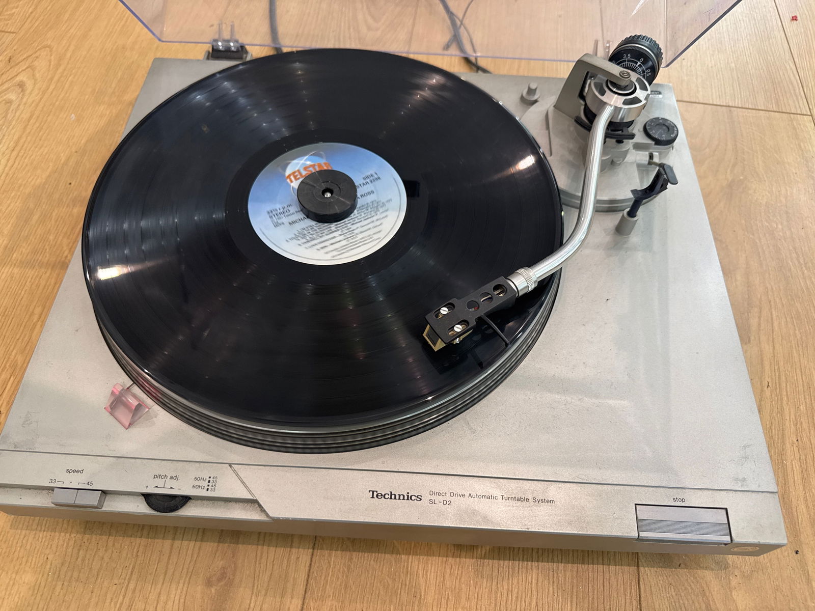 A technics SL-D2 turn table: Powers on and rotates Please Note: This item cannot be shipped by us. You will need to arrange your own shipping or collect it in person. ; Dust cover has areas of melting plastic at the rear.