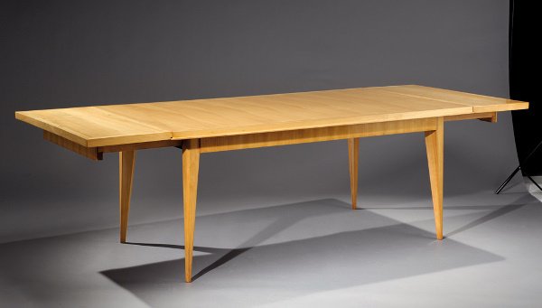 ALFRED PORTENEUVE (1896-1949) Table de salle à mang: ALFRED PORTENEUVE (1896-1949) Table de salle à manger à rallonges en placage de frêne reposant sur quatre pieds galbés. Plateau rectangulaire souligné d'un filet en bordure à décor d'une marque