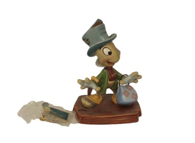 A WDCC 10th Anniversary Jiminy Cricket Figurine and Matching Pin.