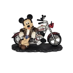 A Mickey Mouse In Front Of A Motorcycle Figurine.