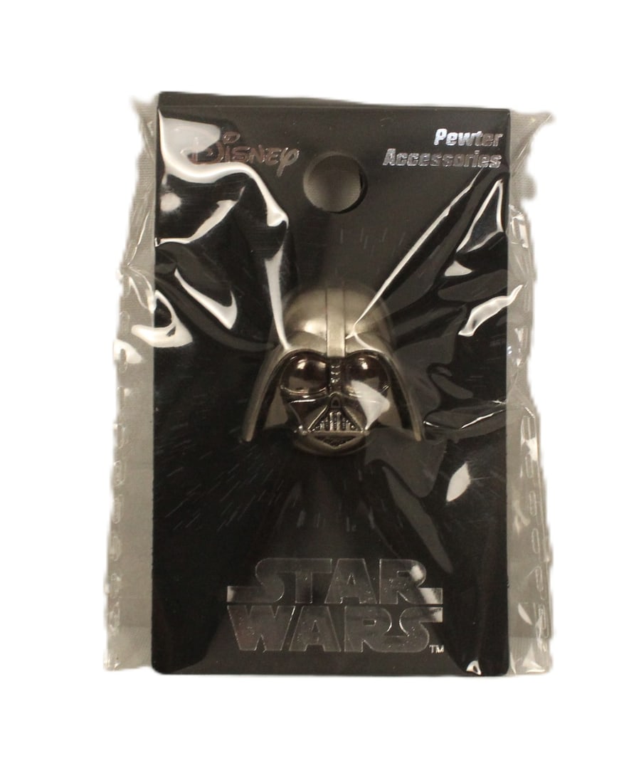 A pewter Darth Vader Mask Pin.: (Monogram) This Darth Vader Helmet Pin also has a loop for a chain or clasp. It is made of pewter, is officially licensed and in new in package.