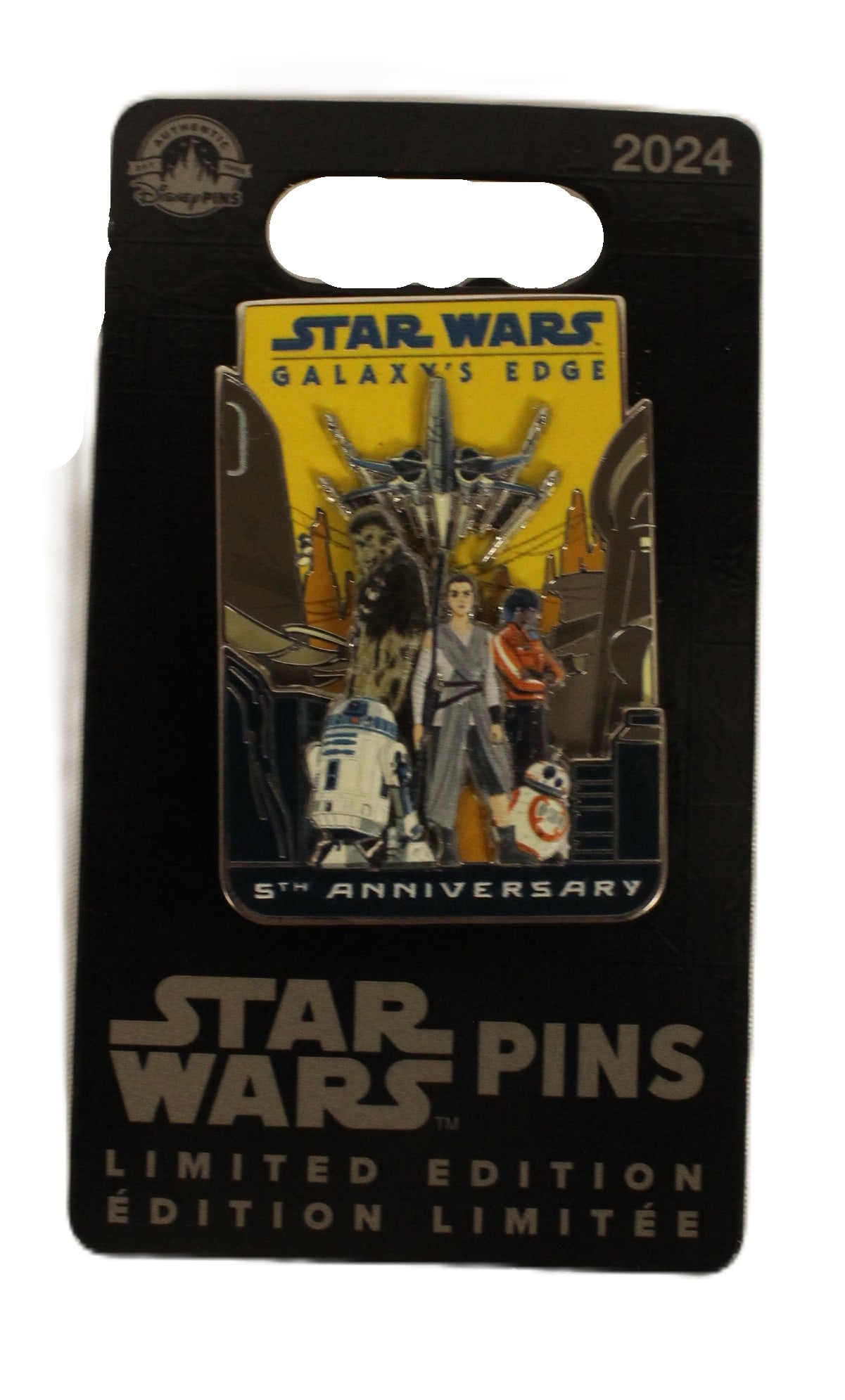 A Star Wars Galaxy's Edge Limited Edition 5th Anniversary Pin.: (Disney Parks, 2004) Opening in 2019, this pin celebrates the 5th anniversary of Disney Parks Star Wars Galaxy's Edge themed area. It features Rey, Chewbacca, R2-D2, BB-8 and Vi Moradi. It is triple