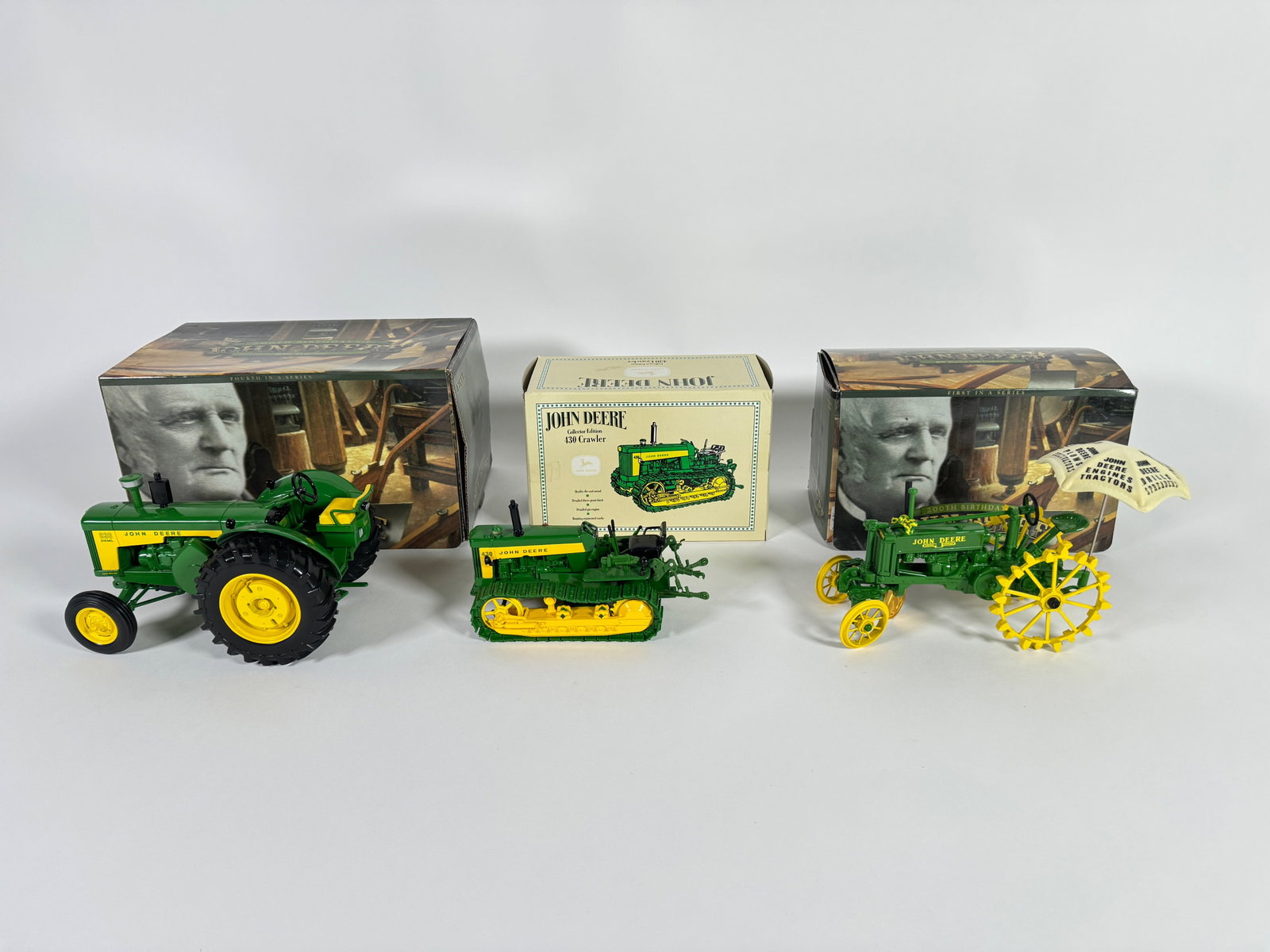 Lot of three John Deere die-cast tractors by Ertl with boxes: Lot of three John Deere die-cast tractors by Ertl with boxes. Consist of; 200th Birthday Edition 830, Collectors Edition 430 Crawler and 200th Birthday Edition BW with umbrella tractors. Scale 1/16th.