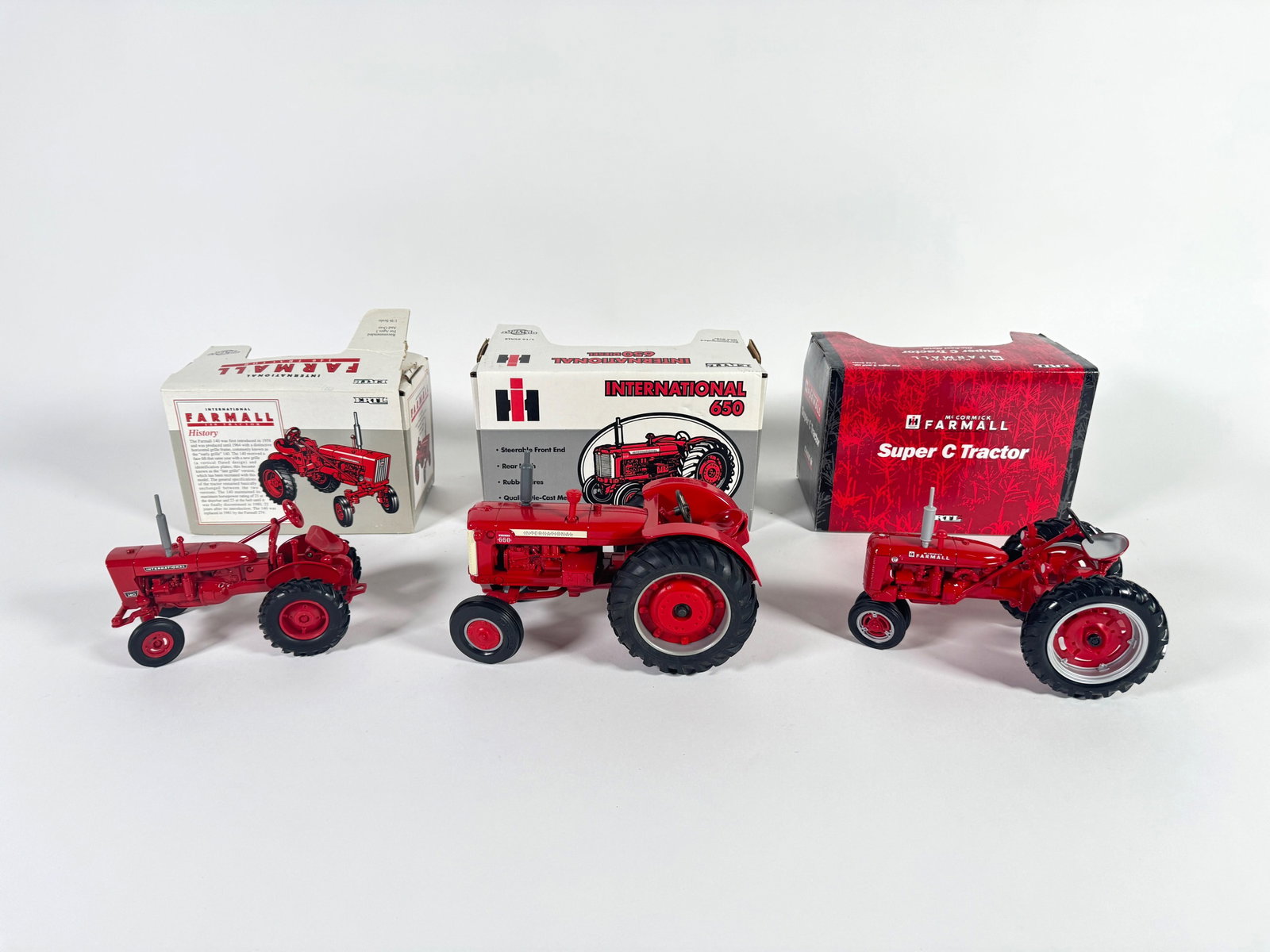 Lot of three McCormick Farmall and International Tractors by Ertl with boxes (1 of 2)