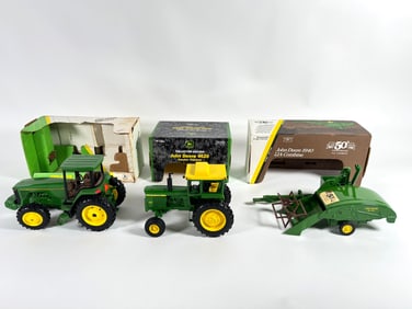 Lot of three John Deere tractors and combine by Ertl with boxes