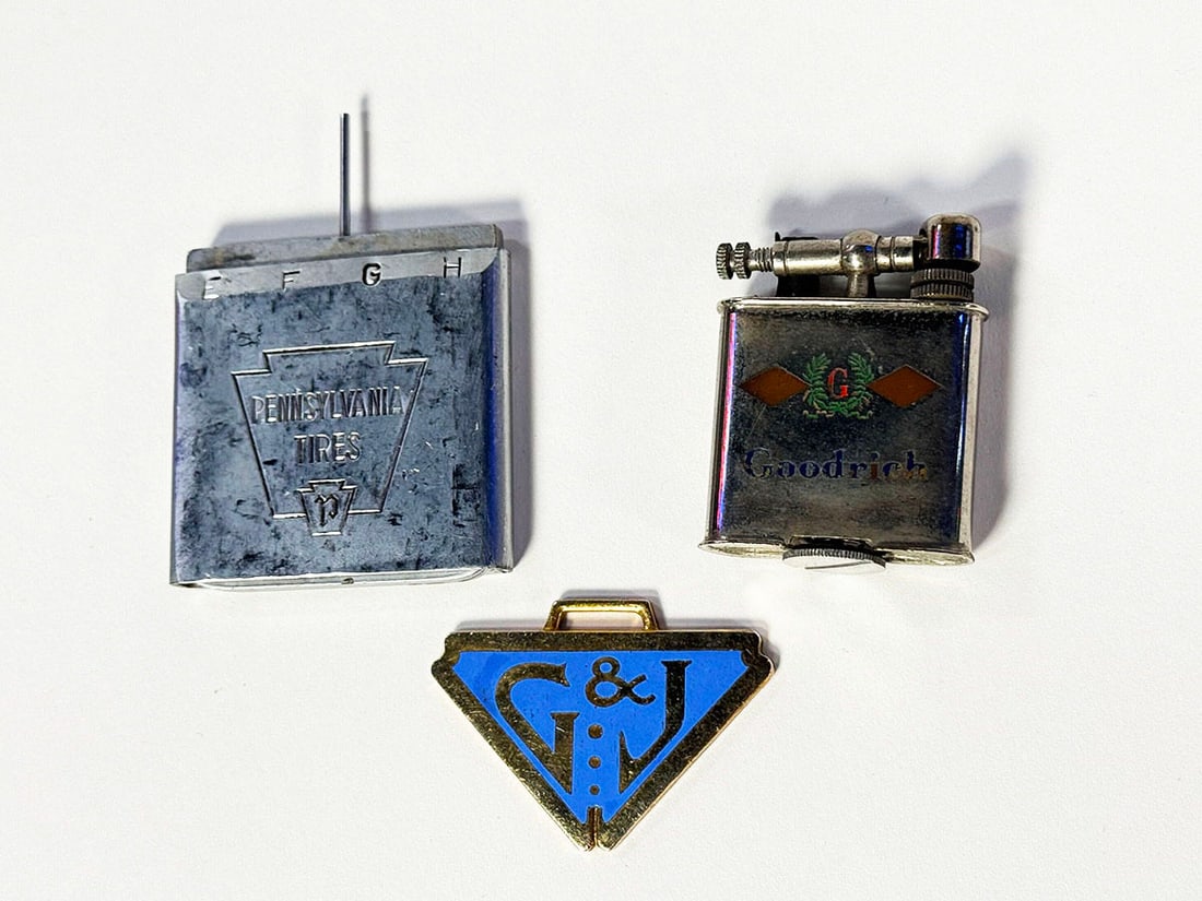 Lot of three 1920s-40s filling station promotional items.: Lot of three 1920s-40s filling station promotional items. Includes 1920s Goodrich pocket lighter, 1930s G&J Tires metal key fob, and 1940s Pennsylvania Tires tread gauge. Condition: Various. Size of t