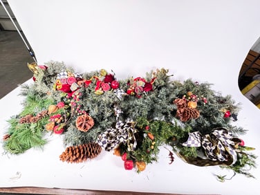 Several strands of holiday garland with McKenzie-Childs Courtly Check bows and ribbons attached.