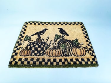 MacKenzie-Childs Courtly Check woven Fall door mat with gourds and ravens depicted.