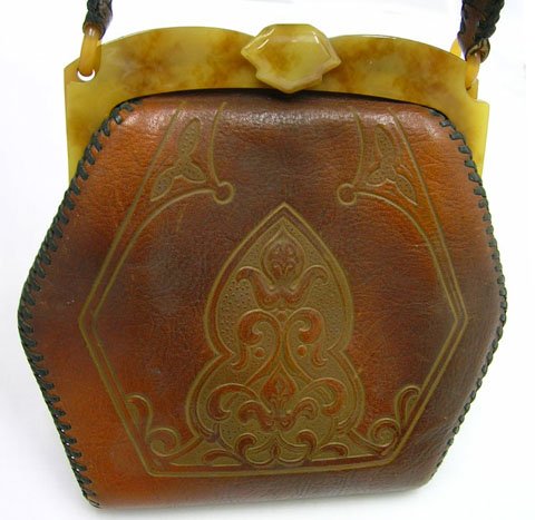 1920'S TOOLED LEATHER & BAKELITE FRAME PURSE: 1920'S TOOLED LEATHER & BAKELITE FRAME PURSE * PURSE IS APROX. 7" FROM LATCH TO BOTTOM X 7" WIDE * IS MARKED ON TAG INSIDE SPANISH CRAFT * IS IN GRADE 9 CONDITION * LEATHER VERY SOFT *