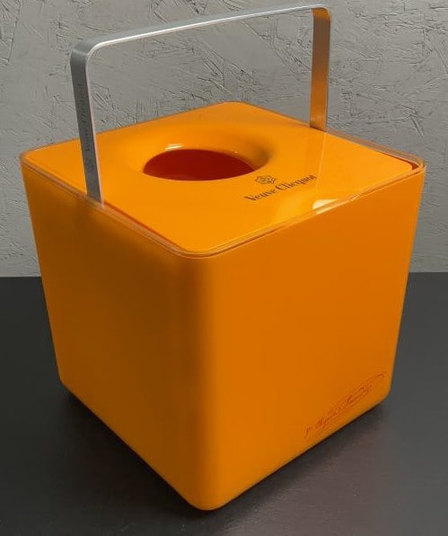Veuve Cliquot Porsche Design Champagne Bucket: Buyer Premium 10% BP MFG Veuve Cliquot Porsche Design Champagne Bucket Located in: Chattanooga, TN Veuve Clicquot "Ice Cube" chiller bucket, Porsche Design, is made of yellow/orange polycarbonate and
