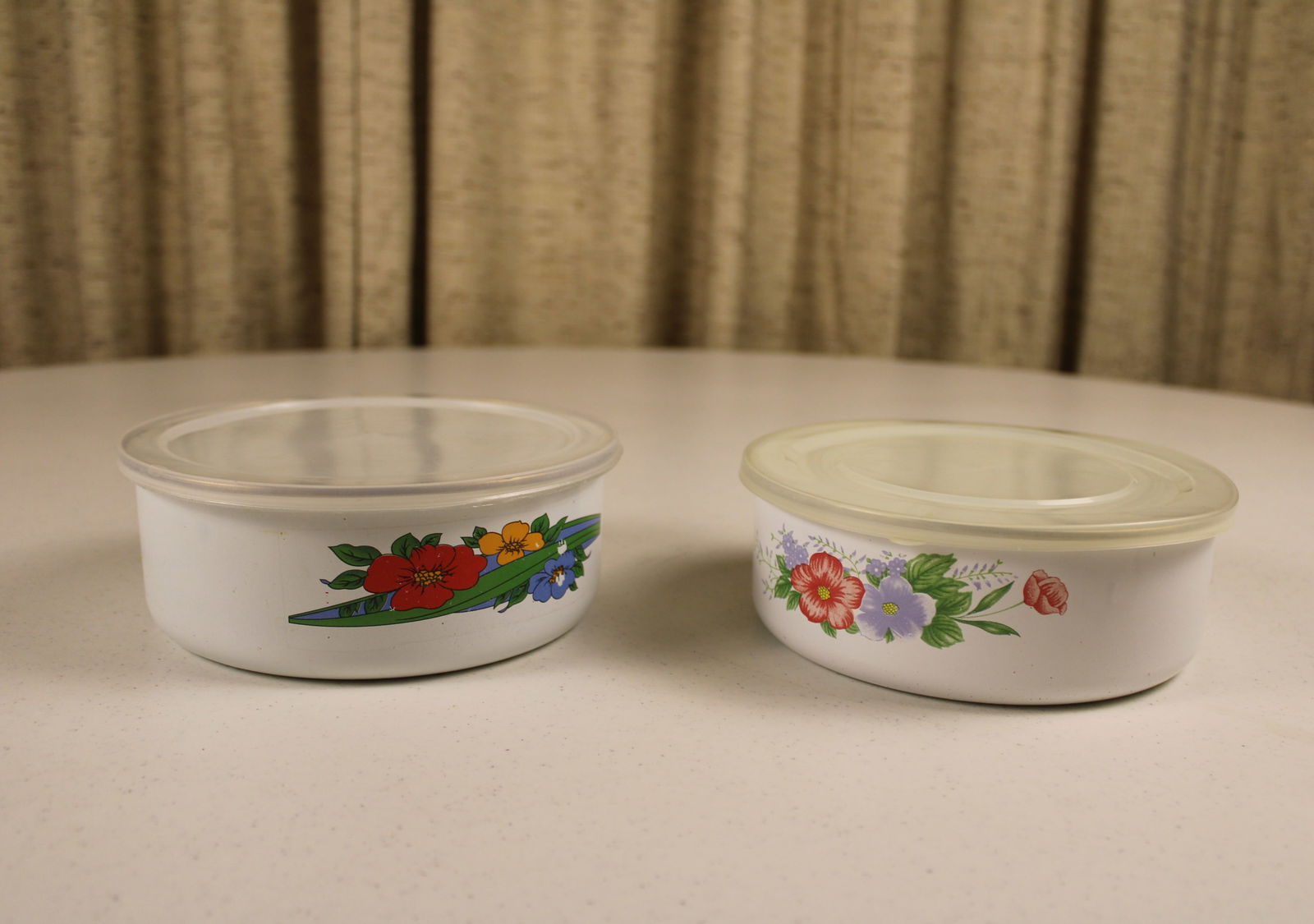 Set of 2 vintage enamel storage containers with plastic lids and floral motifs, in good used: Set of 2 vintage enamel storage containers with plastic lids and floral motifs, in good used condition, some chips to design on one.