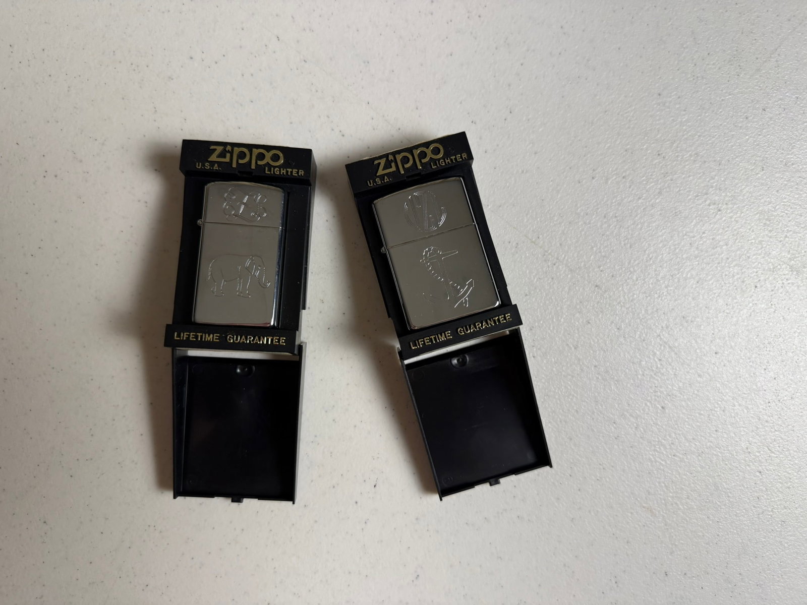 Zippo Lighters Engraved: 2 Engraved Zippo Lighters in original packaging One engraved with anchor 1 with elephant, both with initials