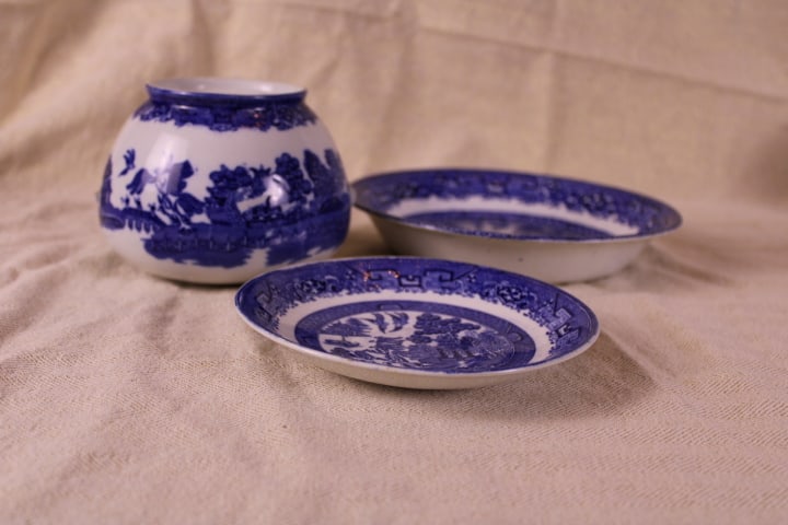 Blue Willow Sugar Dish and Saucers: Used and missing handles sugar jar, made in England mark Saucer in fair condition, marked made in England Bowl in fair condition, also marked made in England. This chinoiserie design, which originated