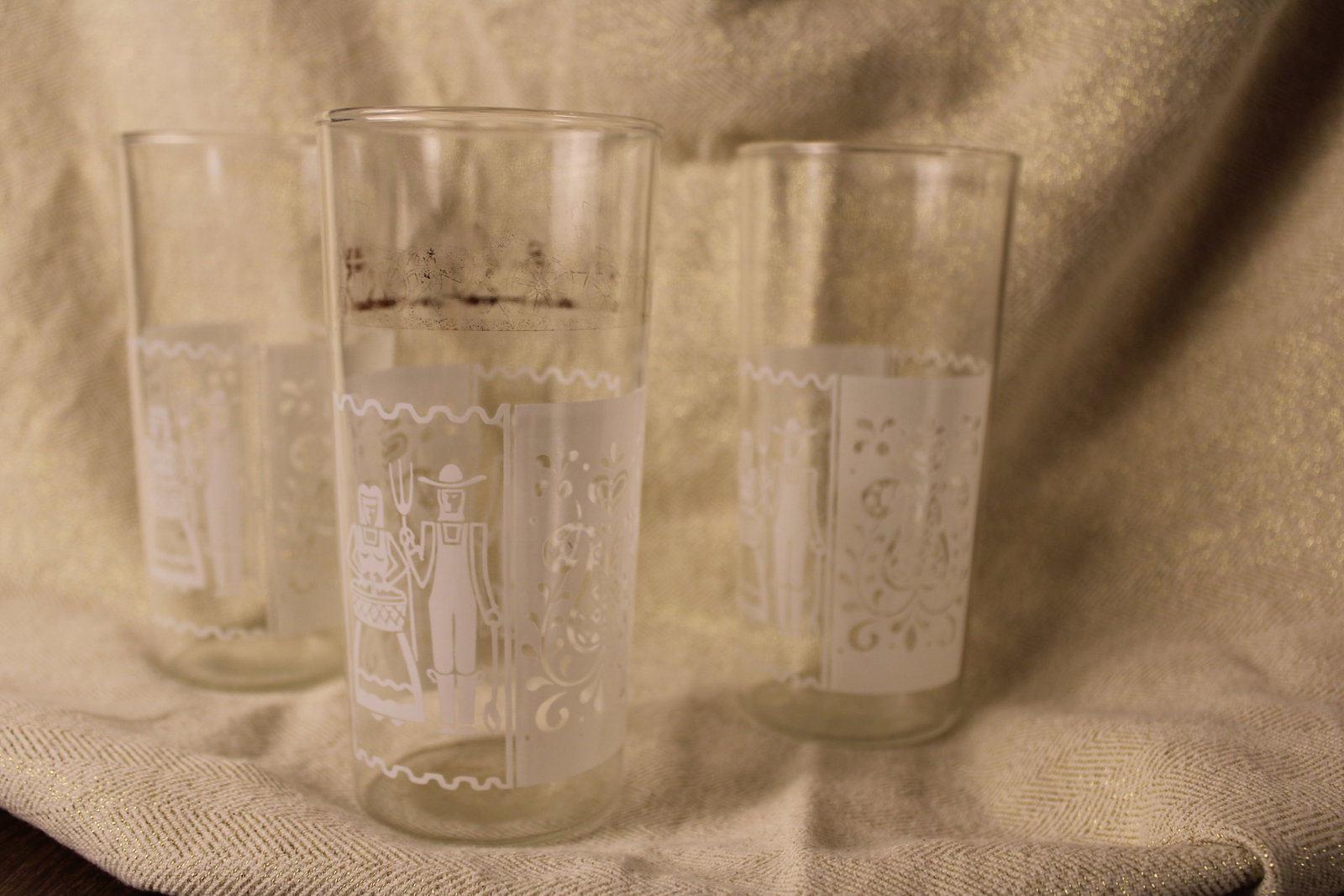 Amish Motif Glasses Trio: Set of 3 Amish Motif Glasses, in well-loved pre-owned condition, gold pattern near top rim of glass is nearly rubbed off