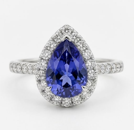 Certified 2.5 Ct Pear Natural Tanzanite 14K White Gold Halo Setting with Pave Shank Ring: This certified fine jewelry piece features a 2.5 carat natural Tanzanite in a Pear cut, crafted in 14K White Gold. The Halo Setting with Pave Shank design highlights the beauty of the natural center s