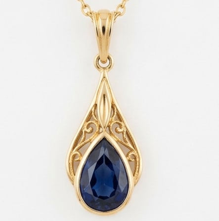 5.00 CT Sapphire Lab-Grown Pendent in Yellow Gold: An exceptional 5.00 carat lab-grown sapphire pendent, expertly crafted in luxurious Yellow Gold. The pear cut bezel set in vintage gold filigree drop design highlights the brilliance of the lab-grown