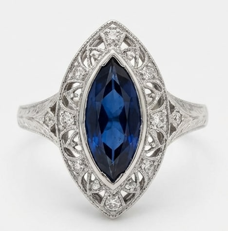 5.00 CT Sapphire Lab-Grown Ring in White Gold: An exceptional 5.00 carat lab-grown sapphire ring, expertly crafted in luxurious White Gold. The marquise cut bezel set with vintage filigree design highlights the brilliance of the lab-grown center s
