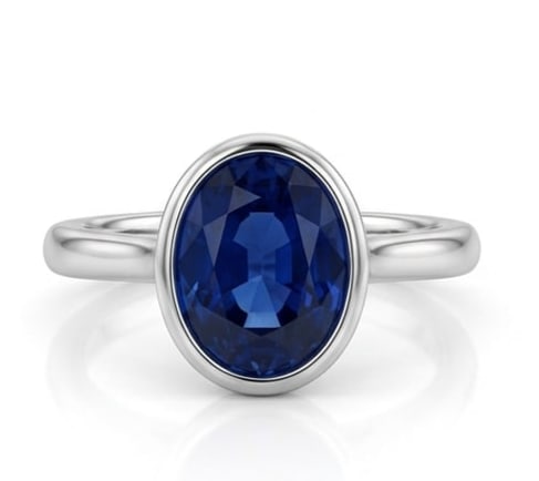 5.00 CT Sapphire Lab-Grown Ring in White Gold: An exceptional 5.00 carat lab-grown sapphire ring, expertly crafted in luxurious White Gold. The oval cut bezel set solitaire design highlights the brilliance of the lab-grown center stone, accented w