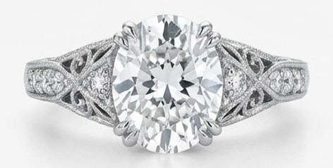 IGI Lab Grown 6.00 Ct Oval Diamond Ring – Vintage Oval Solitaire with Filigree Shoulders – / in: IGI Certified Lab Grown Diamond Center Stone Color E-F Clarity VVS1-VS1 Side Stone Lab Grown Diamond A timeless statement, this ring highlights a 6.00 carat lab grown Oval center diamond as the focal