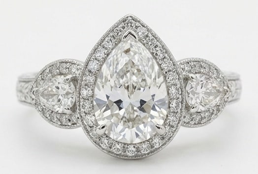 IGI Lab Grown 5.00 Ct Pear Shape Diamond Ring – Vintage Three-Stone Pear Halo – / in 14K White: IGI Certified Lab Grown Diamond Center Stone Color E-F Clarity VVS1-VS1 Side Stone Lab Grown Diamond Beautifully styled, this ring is anchored by a 5.00 carat lab grown Pear Shape center diamond as th