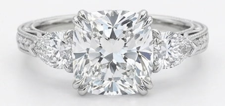 IGI Lab Grown 6.00 Ct Cushion (Modified Brilliant) Diamond Ring – Vintage Three-Stone Cushion with: IGI Certified Lab Grown Diamond Center Stone Color E-F Clarity VVS1-VS1 Side Stone Lab Grown Diamond A timeless statement, this ring highlights a 6.00 carat lab grown Cushion (Modified Brilliant) cent