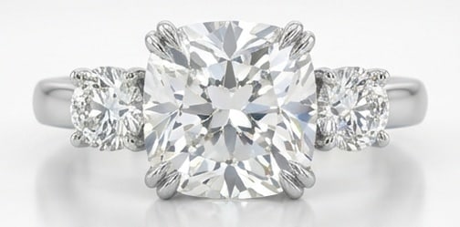 IGI Lab Grown 4.00 Ct Cushion (Modified Brilliant) Diamond Ring Three-Stone Cushion with Round Sides: IGI Certified Lab Grown Diamond Center Stone Color E-F Clarity VVS1-VS1 Side Stone Lab Grown Diamond Sophisticated and modern, this ring is defined by a 4.00 carat lab grown Cushion (Modified Brillian