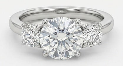 IGI Lab Grown 5.00 Ct Round Brilliant Diamond Ring – Classic Three-Stone Round – / in 14K White: IGI Certified Lab Grown Diamond Center Stone Color E-F Clarity VVS1-VS1 Side Stone Lab Grown Diamond Chic and distinctive, this ring showcases a 5.00 carat lab grown Round Brilliant center diamond. Se