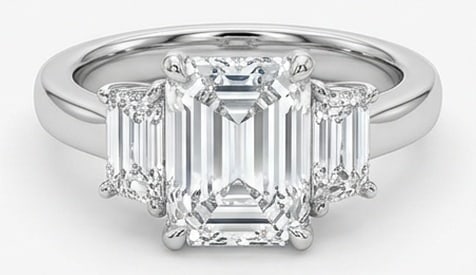 IGI Lab Grown 5.00 Ct Emerald Diamond Ring – Three-stone setting with step-cut trapezoid side: IGI Certified Lab Grown Diamond Center Stone Color E-F Clarity VVS1-VS1 Side Stone Lab Grown Diamond Graceful and eye-catching, this ring is set with a 5.00 carat lab grown Emerald center diamond. Set