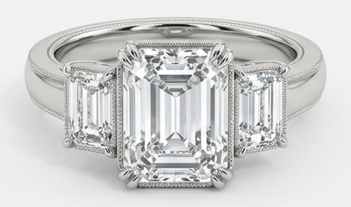 IGI Lab Grown 5.00 Ct Emerald Diamond Ring – Three-stone setting with milgrain bezel details on: IGI Certified Lab Grown Diamond Center Stone Color E-F Clarity VVS1-VS1 Side Stone Lab Grown Diamond Classic with a contemporary edge, this ring spotlights a 5.00 carat lab grown Emerald center diamon