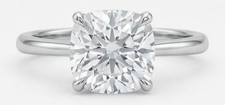Lab Grown 6.00 Ct Cushion (Modified Brilliant) Diamond Ring – Modern Classic Four-Prong Solitaire: Beautifully styled, this ring is anchored by a 6.00 carat lab grown Cushion (Modified Brilliant) center diamond. Featuring a Modern Classic Four-Prong Solitaire aesthetic, balancing bold geometry with