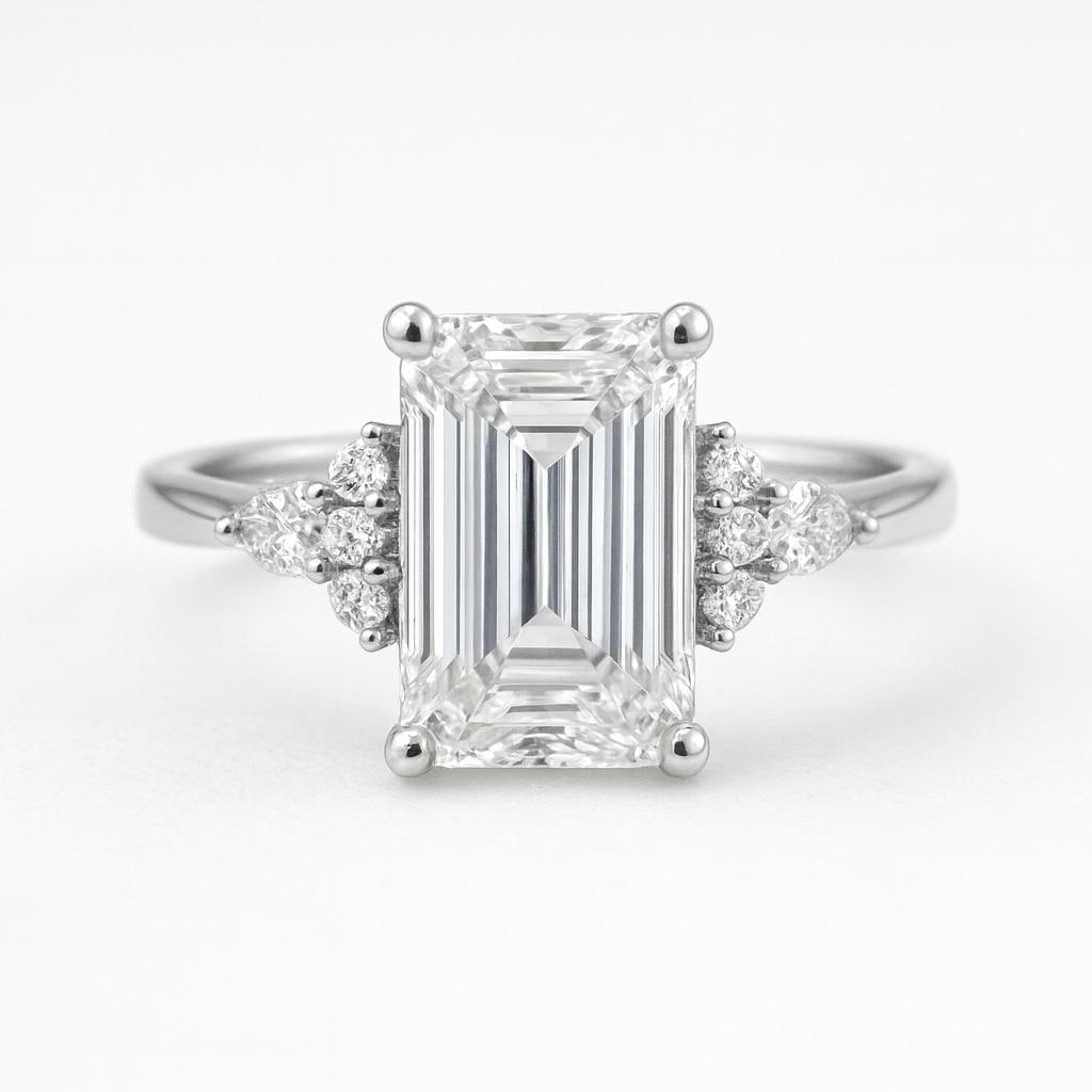 5.50 CT Lab Grown Emerald Cut Diamond Ring with Round Side Stones in 14K White Gold: Elegant 5.50 carat lab grown emerald cut diamond centerpiece, accented with clusters of lab grown round brilliant side stones on each shoulder. Crafted in 14K white gold with a high-polish finish, off