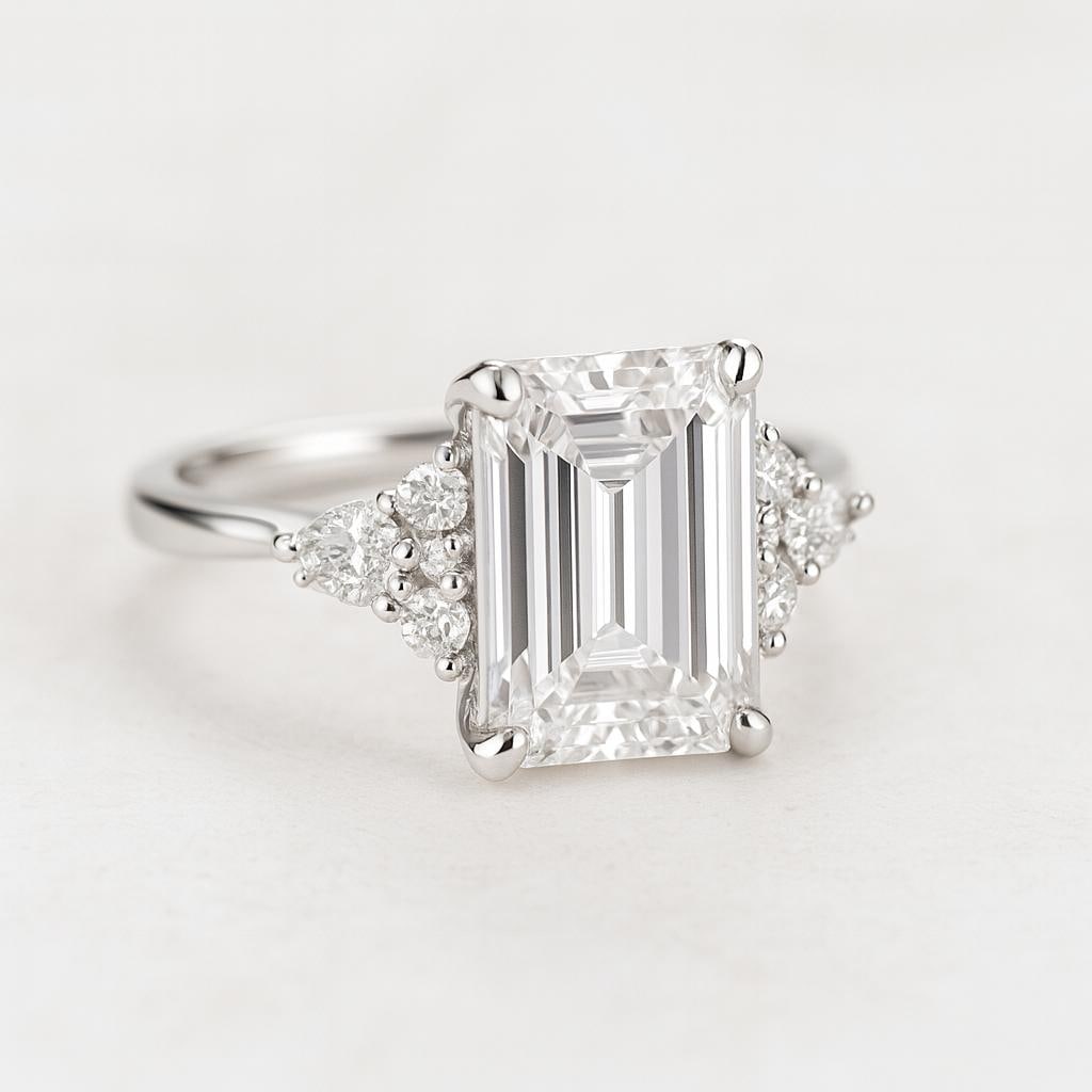 5 CT Lab Grown Emerald Cut Diamond Ring with Round & Pear Side Stones in 14K White Gold: Stunning 5 carat lab grown emerald cut diamond centerpiece, accented with clusters of lab grown round brilliant and pear-shaped side stones for a luxurious look. Expertly set in 14K white gold with a 