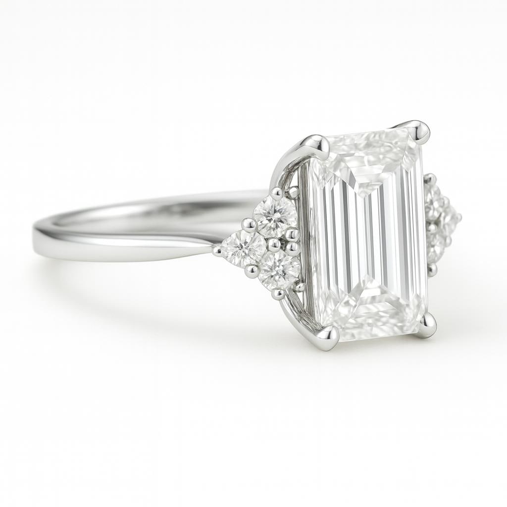 5 CT Lab Grown Emerald Cut Diamond Ring with Round Side Stones in 14K White Gold: Elegant 5 carat lab grown emerald cut diamond centerpiece, accented by clusters of lab grown round brilliant side stones on each shoulder. Set in 14K white gold with a sleek high-polish finish, this d