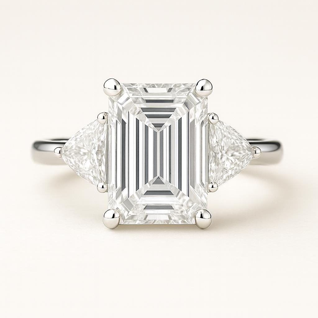 5.50 CT Lab Grown Emerald Cut Three Stone Diamond Ring in 14K White Gold: Sophisticated 5.50 carat lab grown emerald cut diamond centerpiece, flanked by two brilliant trillion cut diamond side stones. Crafted in 14K white gold, this timeless three-stone ring design radiates