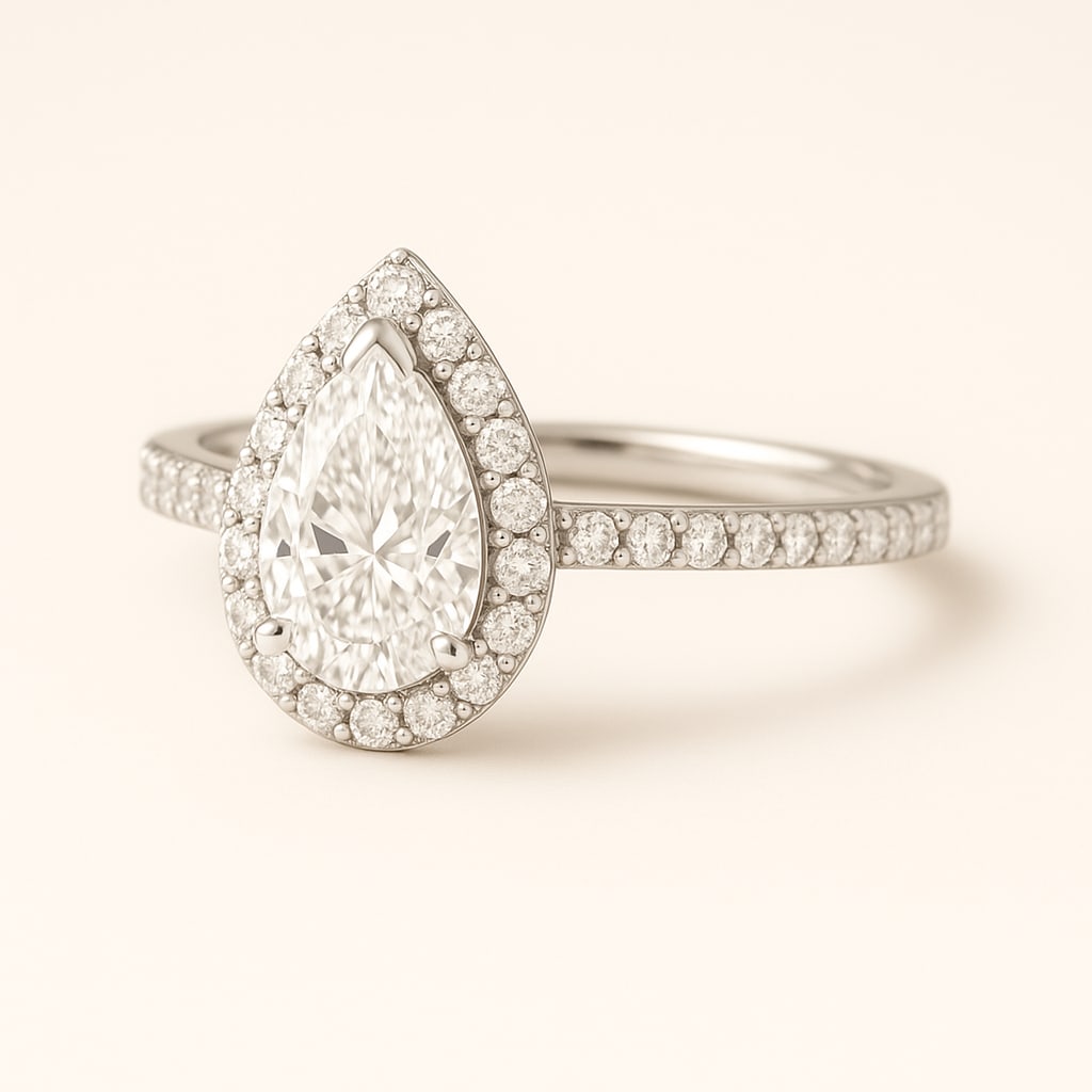 4.50 CT Lab Grown Pear Cut Diamond Halo Ring with Pavé Band in 14K White Gold: Elegant 4.50 carat lab grown pear cut diamond, encircled by a halo of lab grown round brilliant diamonds and set on a polished 14K white gold pavé band. A timeless engagement ring that radiates spark