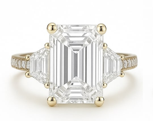 8.50 CT Lab Grown Emerald Cut Diamond Three-Stone Ring with Trapezoid Side Stones in 14K Yellow Gold: Magnificent 8.50 carat lab grown emerald cut diamond, flanked by trapezoid-shaped side stones and set on a polished 14K yellow gold band with pavé accents. A luxurious engagement ring that exudes sop