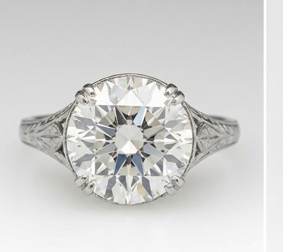 Lab Grown 5.00 Ct Round Brilliant Diamond Ring – Solitaire with Vintage Engraved Shoulders – /: Chic and distinctive, this ring showcases a 5.00 carat lab grown Round Brilliant center diamond. White Gold gives the piece a refined, neutral foundation for daily wear or events. The overall style fo
