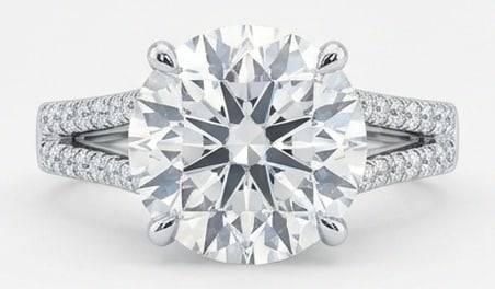 Lab Grown 8.00 Ct Round Brilliant Diamond Ring – Modern Split Shank Pave Solitaire – / in 14K: Distinctive in silhouette, this ring centers on a 8.00 carat lab grown Round Brilliant center diamond as the focal point. The modern split shank pave solitaire design is paired with White Gold for a s