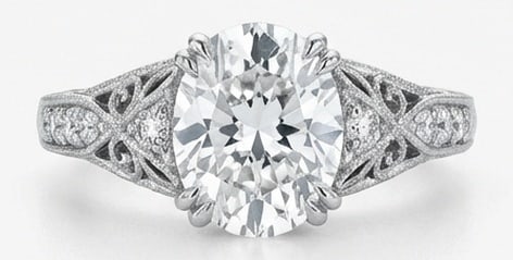 Lab Grown 6.00 Ct Oval Diamond Ring – Vintage Oval Solitaire with Filigree Shoulders – / in 14K: A timeless statement, this ring highlights a 6.00 carat lab grown Oval center diamond as the focal point. The vintage oval solitaire with filigree shoulders design is paired with White Gold for a slee
