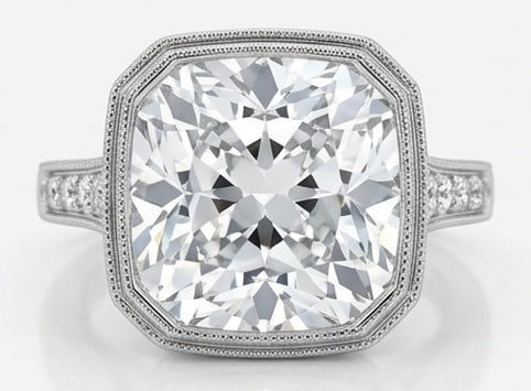 Lab Grown 5.00 Ct Cushion (Modified Brilliant) Diamond Ring – Bezel Set Cushion Halo with Pave: Sophisticated and modern, this ring is defined by a 5.00 carat lab grown Cushion (Modified Brilliant) center diamond as the focal point. The bezel set cushion halo with pave shoulders design is paired