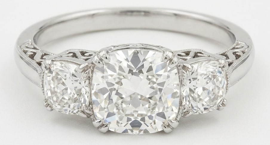 Lab Grown 5.00 Ct Cushion (Old Mine Look) Diamond Ring – Antique Three-Stone Cushion with Scroll: Bold yet refined, this design showcases a 5.00 carat lab grown Cushion (Old Mine Look) center diamond. White Gold gives the piece a refined, neutral foundation for daily wear or events. The overall st